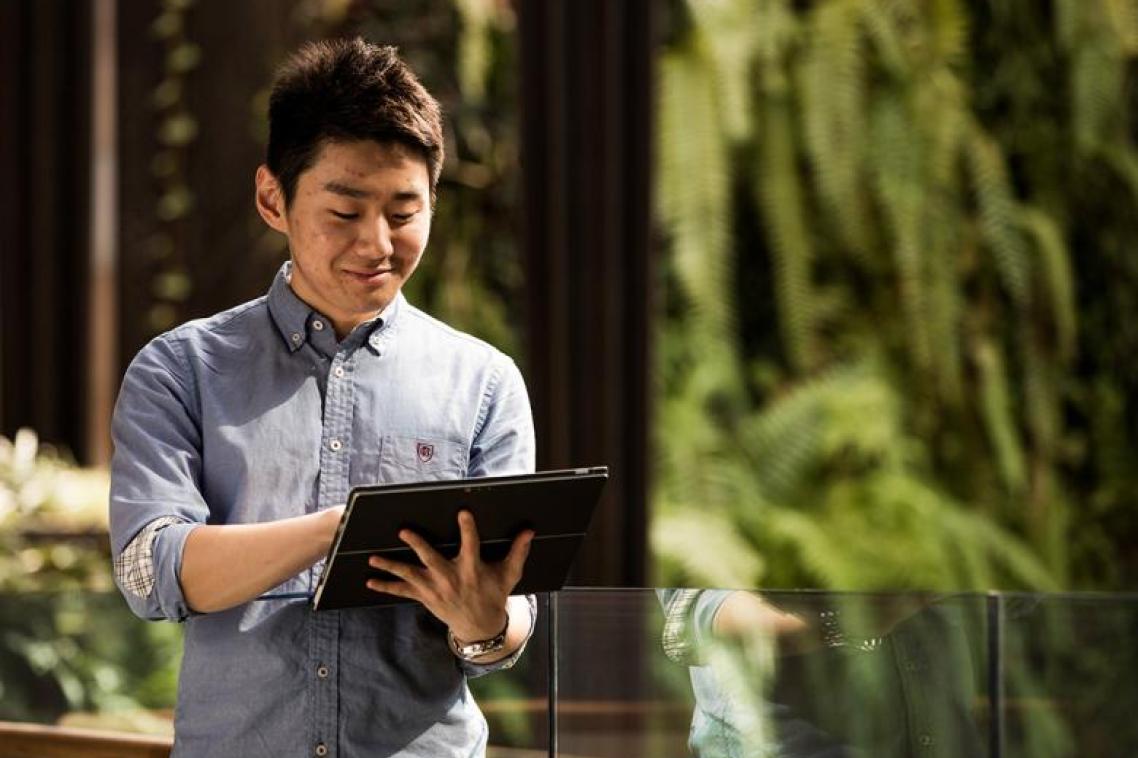 A person walking while using an iPad.